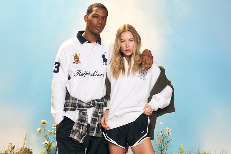 Man and woman in white Ralph Lauren and Nike sportswear against a blue sky.